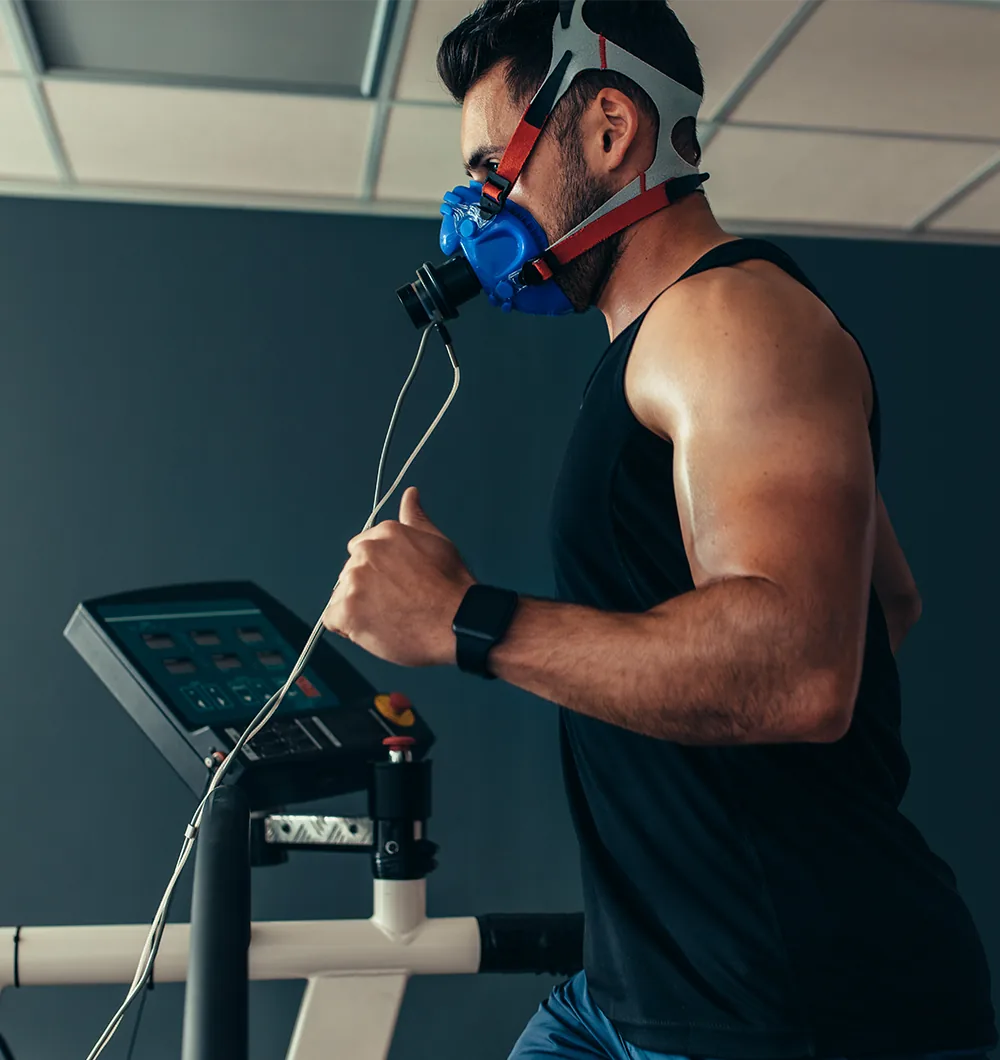 Läufer mit Atemmaske für die Spirometrie auf einem Laufband.